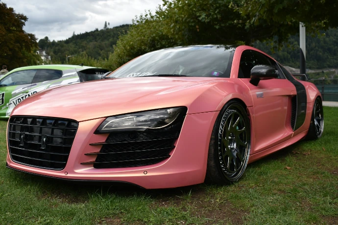 a pink car is parked in the grass